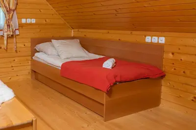 a bed in a log cabin with a red blanket at Chalet Ajda in Bohinj