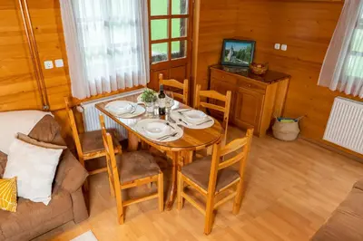 a dining room with a table and chairs and a television at Chalet Ajda in Bohinj