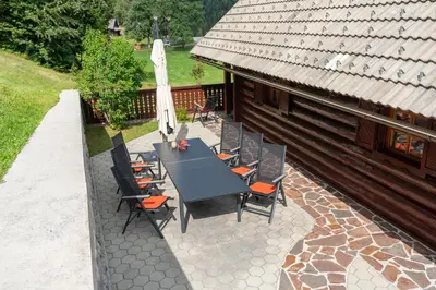 a patio with a table and chairs and a building at Chalet Ajda in Bohinj