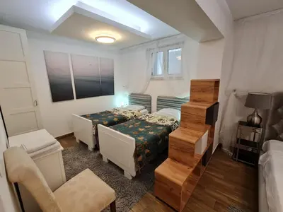 a small bedroom with two beds and a staircase at NUMBER 10 Apartments in Bled