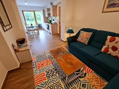 a living room with a green couch and a rug at NUMBER 10 Apartments in Bled