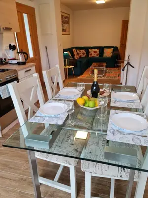 a glass table with chairs and a bottle of wine at NUMBER 10 Apartments in Bled