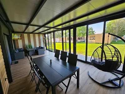 a table and chairs in a room with a large window at Mobilna hiška pod Lipo in Velenje