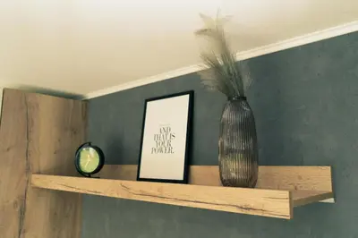 a shelf with a vase and a picture on it at Mobilna hiška pod Lipo in Velenje