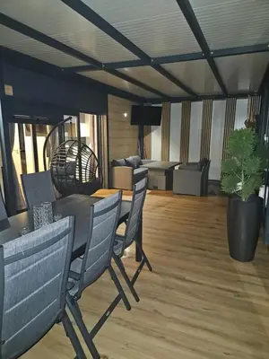 a living room with a table and chairs and a couch at Mobilna hiška pod Lipo in Velenje