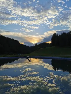 a reflection of the sky in a river at sunset at Valle Divina in Mislinja