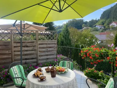 a table with a yellow umbrella on a patio at Villa СARPE DIEM in Laško