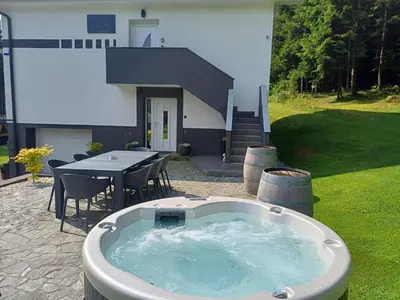 a hot tub in the yard of a house at Green Garden House in Zreče