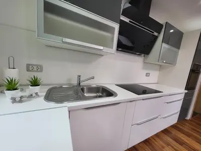 a white kitchen with a sink and a microwave at Green Garden House in Zreče