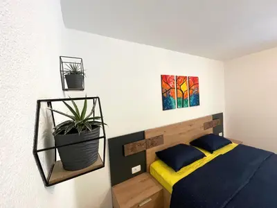 a bedroom with a bed and two paintings on the wall at Apartments and rooms pri Bašlju in Cerkno
