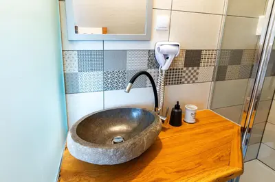 a bathroom with a bowl sink on a wooden counter at Turistična kmetija Grabnar in Bled