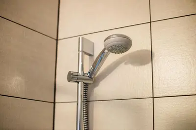 a shower with a shower head on a tiled wall at Turistična kmetija Grabnar in Bled
