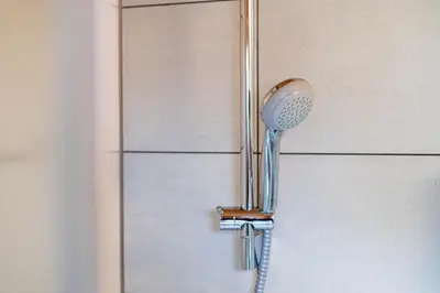 a shower head is hanging on a wall at Turistična kmetija Grabnar in Bled