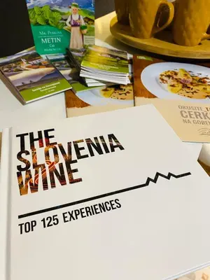 a sign on a table with books and plates of food at Rooms & Apartment ZALA Near Airport & Cable Car in Cerklje na Gorenjskem