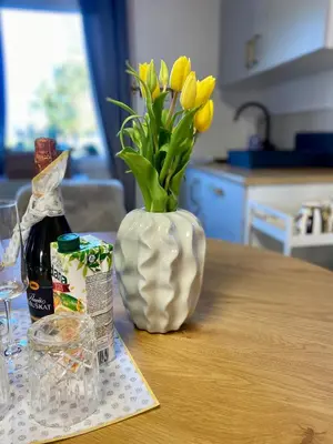 a vase with yellow tulips in it on a table at Rooms & Apartment ZALA Near Airport & Cable Car in Cerklje na Gorenjskem