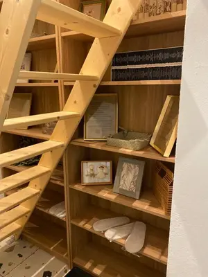 a wooden library with wooden shelves and books at Rooms & Apartment ZALA Near Airport & Cable Car in Cerklje na Gorenjskem