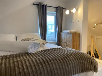 a bedroom with a large bed with a window at Rooms & Apartment ZALA Near Airport & Cable Car in Cerklje na Gorenjskem