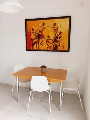 a dining room table with two chairs and a painting on the wall at Green Bee Apartment in Lesce