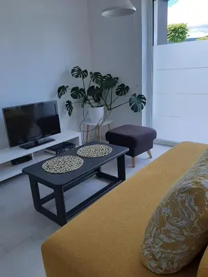 a living room with a coffee table and a tv at Green Bee Apartment in Lesce