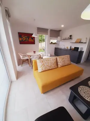 a living room with a yellow couch and a table at Green Bee Apartment in Lesce