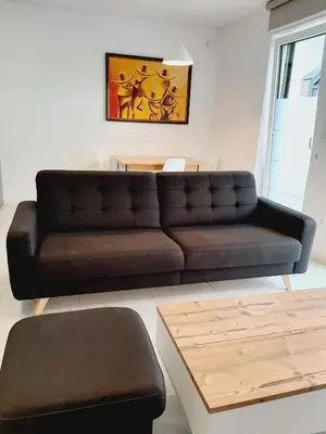 a living room with a brown couch and a table at Green Bee Apartment in Lesce