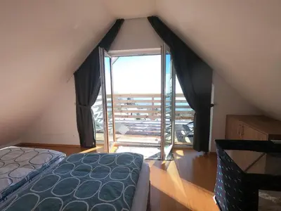 a bedroom with a bed and a large window at Hiša v mesečini - Moonlight house in Cerklje na Gorenjskem