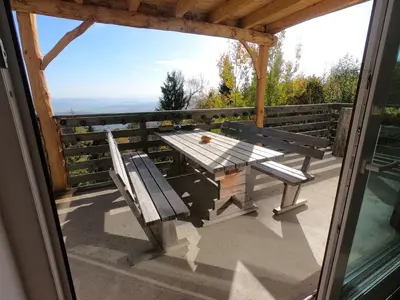 a table and bench on a balcony with a view at Hiša v mesečini - Moonlight house in Cerklje na Gorenjskem
