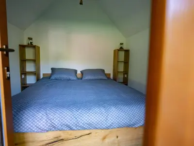 a bedroom with a blue bed with two blue pillows at Glamping Logar in Luče