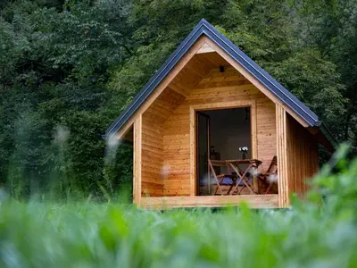 a small wooden cabin with a table and chairs in it at Glamping Logar in Luče