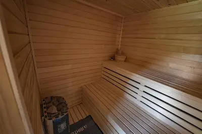 a wooden sauna with a trash can in it at Glamping Logar in Luče