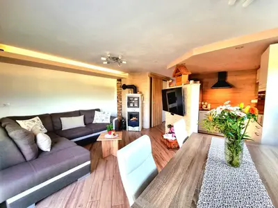 a living room with a couch and a table at GARTNAR HOME -Hiška s pridihom domačnosti in pogledom na hribe. in Radovljica