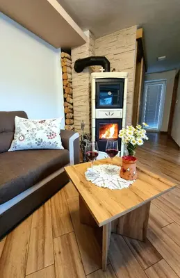 a living room with a couch and a table with wine glasses at GARTNAR HOME -Hiška s pridihom domačnosti in pogledom na hribe. in Radovljica