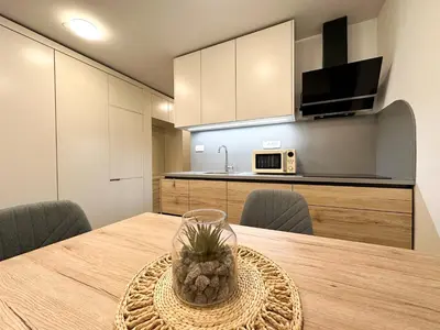 a dining room table with chairs and a microwave at Apartma Prisojnik Kranjska Gora in Kranjska Gora