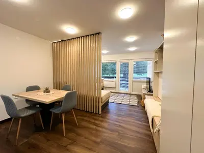 a dining room with a table and a couch at Apartma Prisojnik Kranjska Gora in Kranjska Gora