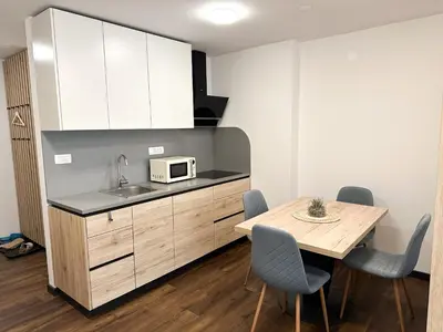 a small kitchen with a table and a microwave at Apartma Prisojnik Kranjska Gora in Kranjska Gora