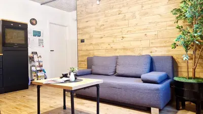 a living room with a blue couch and a table at The Apartment - Ljubljana in Ljubljana