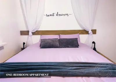 a bedroom with a bed with pink sheets and pillows at The Apartment - Ljubljana in Ljubljana