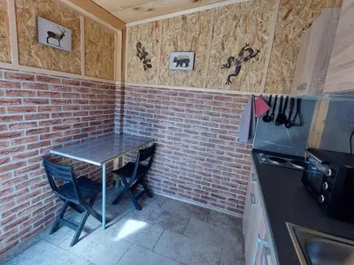 a kitchen with a table and a brick wall at Mike's Rooms in Kobarid