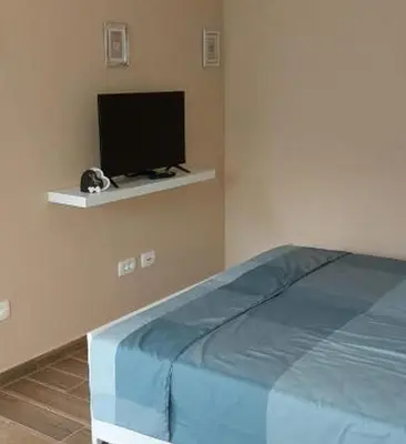 a bedroom with a bed and a flat screen tv at Mike's Rooms in Kobarid