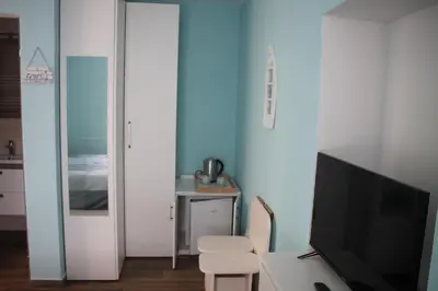 a living room with a tv and a desk with a chair at Mike's Rooms in Kobarid