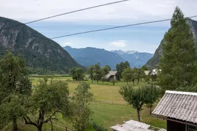 a view of a field with mountains in the background at Apartma Ivano in Bohinj