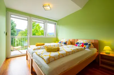 a bedroom with a large bed in front of a window at Apartments Apple Garden 4P in Bled