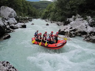 a group of people in a raft on a river at Apartments Apple Garden 4P in Bled