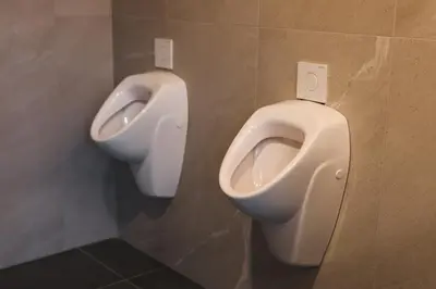 a bathroom with two urinals and a toilet at Tents resort Posestvo SONČNI RAJ in Maribor