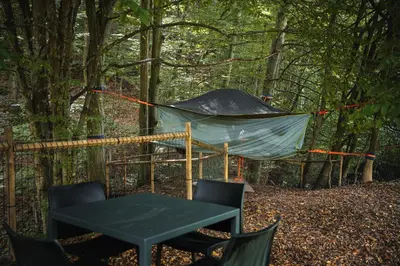 a tent in the woods with a table and chairs at Tents resort Posestvo SONČNI RAJ in Maribor