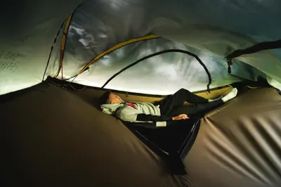 a man is laying inside of a tent at Tents resort Posestvo SONČNI RAJ in Maribor