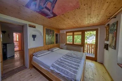 a bedroom with a bed and a wooden ceiling at Cottage surrounded by forests - The Sunny Hill in Griže