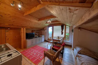 a kitchen and living room of a log cabin at Cottage surrounded by forests - The Sunny Hill in Griže