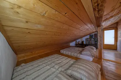 two beds in a room with a wooden ceiling at Cottage surrounded by forests - The Sunny Hill in Griže
