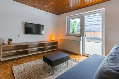 a living room with a tv and a couch at Domačija Log v Bohinju in Bohinjska Bistrica